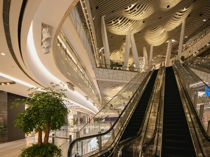 Curved atrium and escalators inside a premium shopping centre