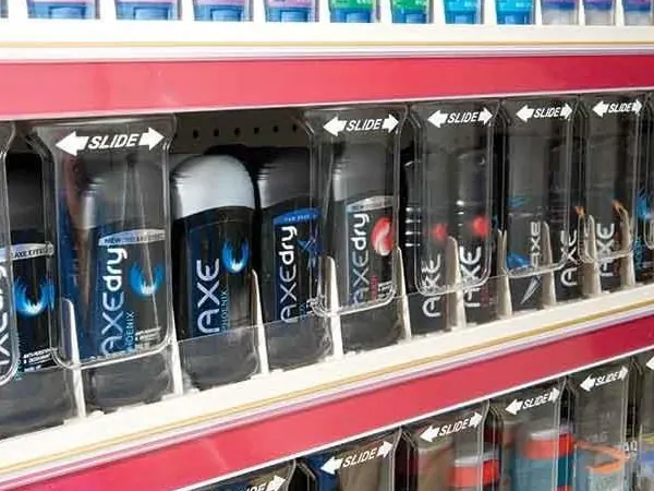 Secure shelving with product pushers holding toiletries in a store aisle