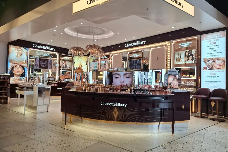 Charlotte Tilbury counter with illuminated lightbox graphics installed in a department store