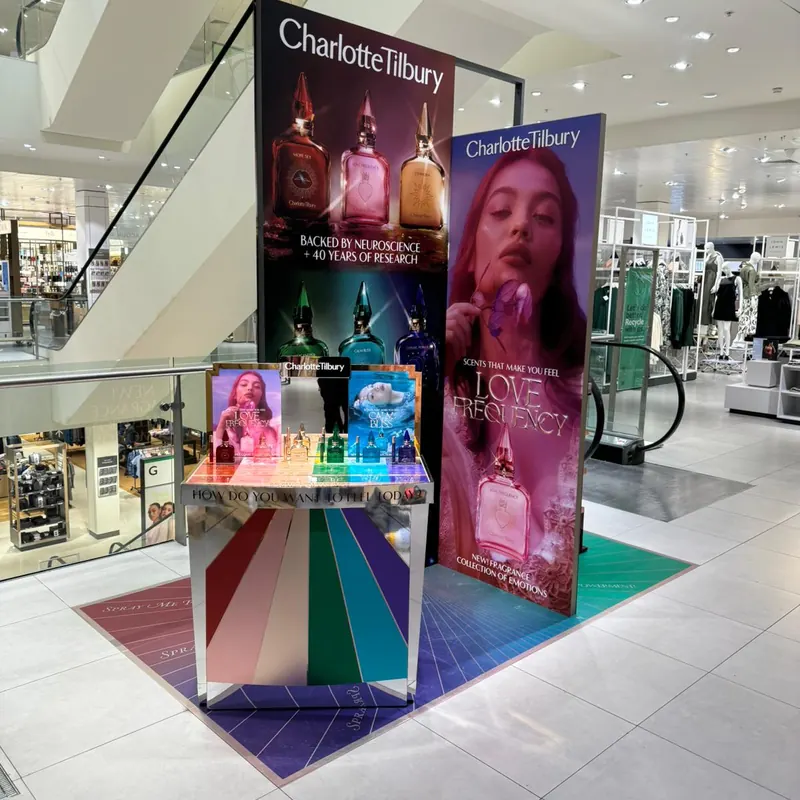 Charlotte Tilbury fragrance activation with illuminated graphics and a rainbow floor installed in a department store